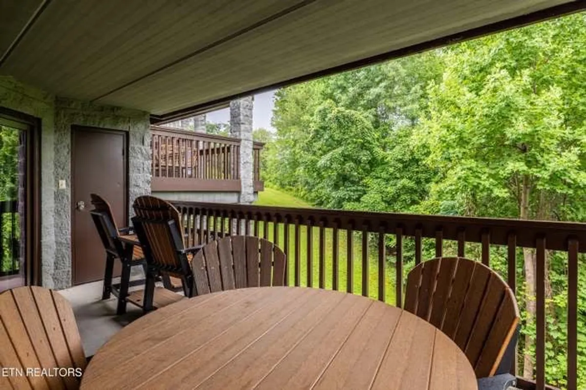 A tranquil outdoor space featuring a wooden table and Adirondack chairs, surrounded by lush greenery and scenic mountain views. Ideal for peaceful moments, wildlife spotting, or gathering with friends or family outdoors.